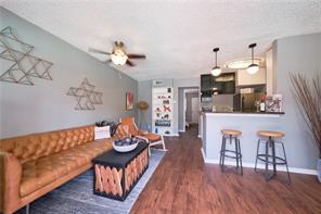 living room with ceiling fan, baseboards, and wood finished floors