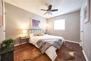 bedroom with ceiling fan, baseboards, and wood finished floors