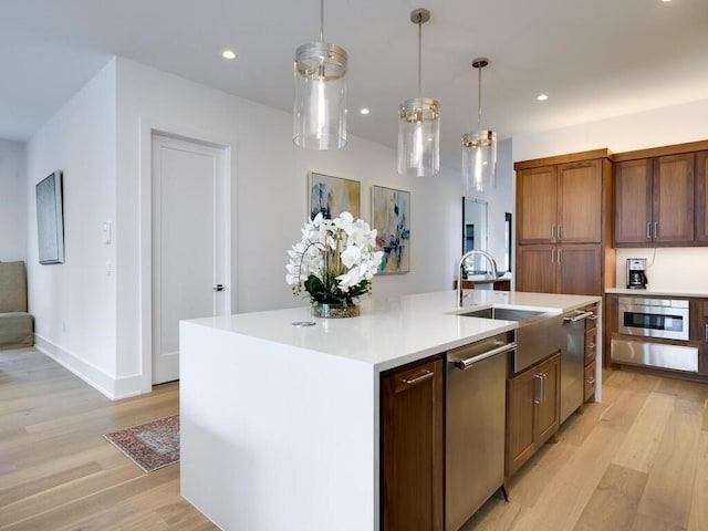 kitchen with a sink, light wood-style floors, stainless steel dishwasher, and recessed lighting