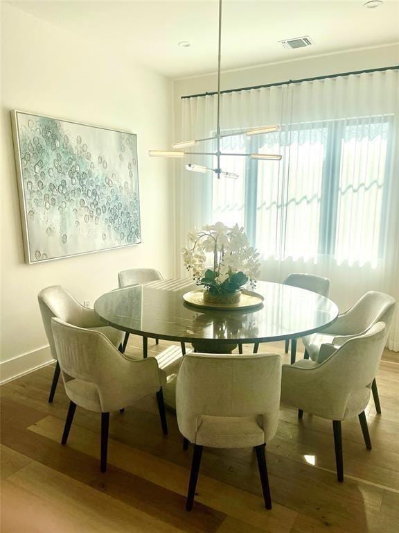 dining space featuring visible vents, baseboards, and wood finished floors