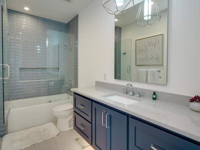 bathroom featuring tile patterned floors, toilet, vanity, and shower / bath combination with glass door