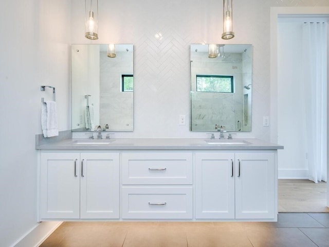 full bath with double vanity, walk in shower, and a sink