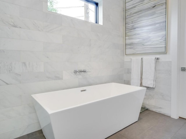 full bath featuring tile walls, a soaking tub, and tile patterned floors