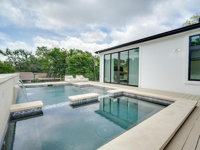 view of swimming pool featuring fence and a pool with connected hot tub