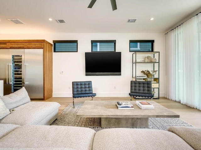 living room with recessed lighting, beverage cooler, visible vents, and light wood-type flooring