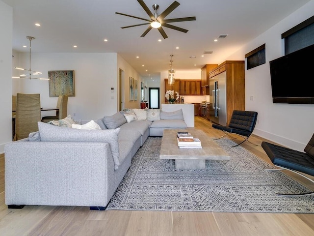 living area with recessed lighting, light wood-type flooring, and baseboards