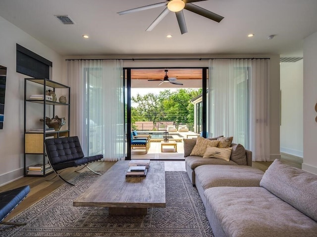 living room featuring visible vents, baseboards, and wood finished floors