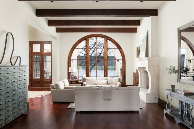 living area with a premium fireplace, beamed ceiling, and wood finished floors