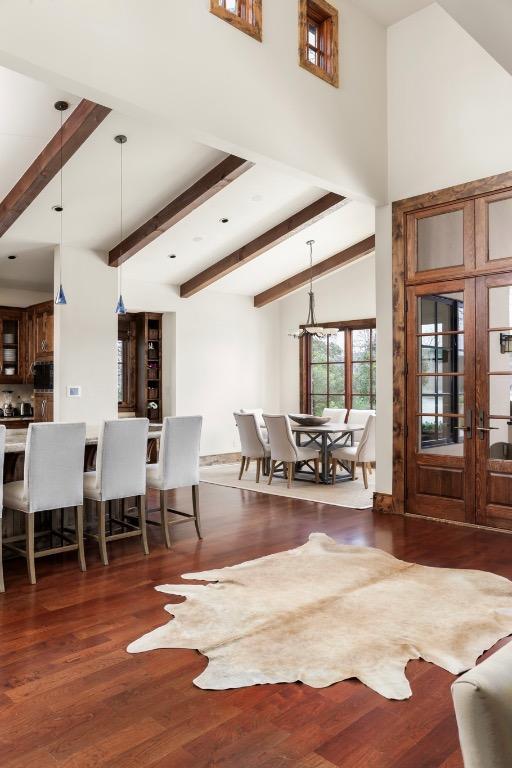 foyer entrance with beam ceiling, high vaulted ceiling, and wood finished floors