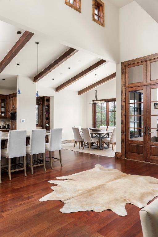 living room featuring wood finished floors, beamed ceiling, and high vaulted ceiling