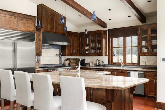 kitchen featuring tasteful backsplash, glass insert cabinets, extractor fan, light stone countertops, and stainless steel appliances