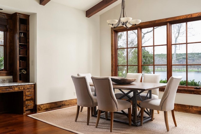 dining area with wood finished floors, baseboards, an inviting chandelier, a water view, and beamed ceiling