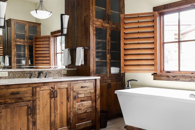 full bathroom with tile patterned floors, a soaking tub, backsplash, and vanity