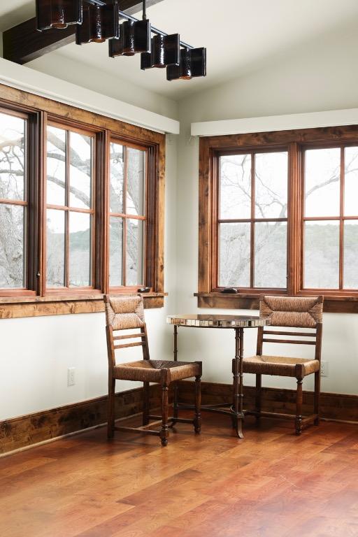 living area with a wealth of natural light, wood finished floors, and vaulted ceiling