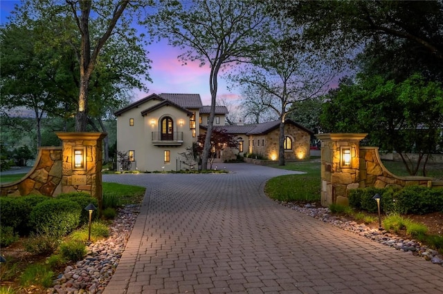 mediterranean / spanish-style house featuring curved driveway and stucco siding