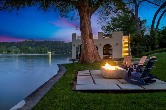 exterior space with a water view, an outdoor fire pit, and a dock