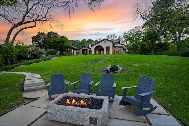 yard at dusk with a patio area and a fire pit