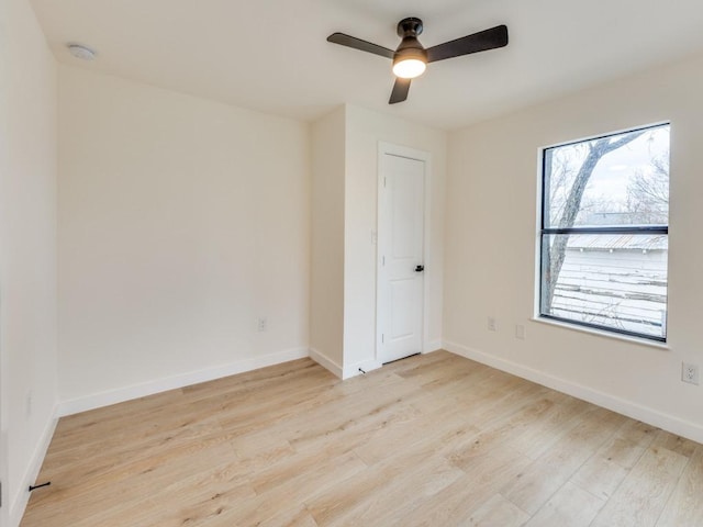 unfurnished room with baseboards, light wood-style floors, and ceiling fan