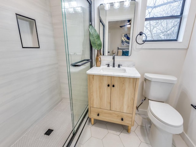 bathroom featuring tile patterned flooring, toilet, vanity, and a stall shower