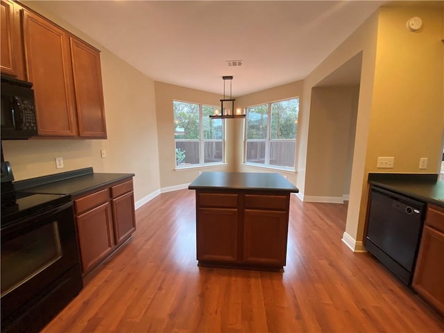 kitchen with black appliances, wood finished floors, dark countertops, and baseboards