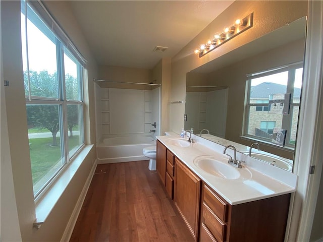 bathroom with wood finished floors, visible vents, and a sink