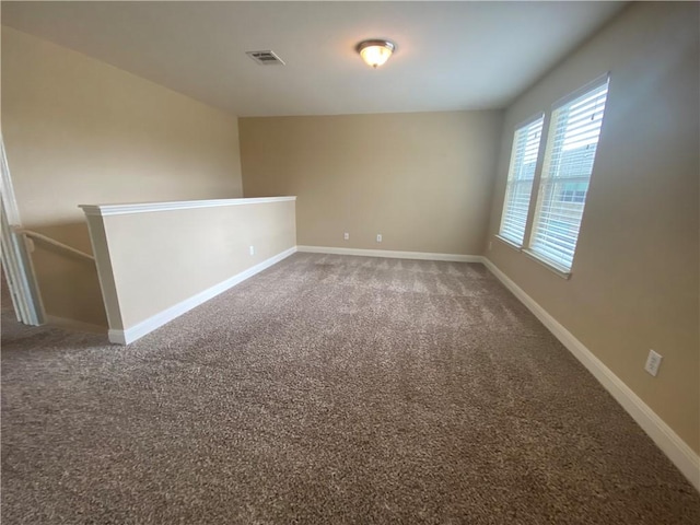 empty room with carpet, baseboards, and visible vents