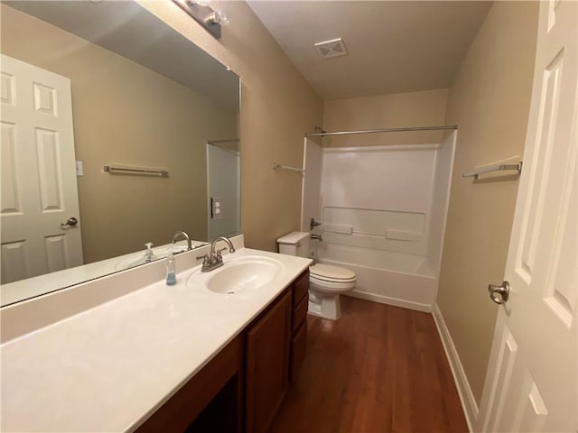 bathroom featuring visible vents, toilet, wood finished floors, vanity, and shower / bathtub combination