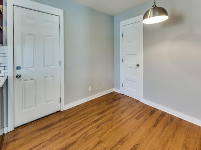 empty room with baseboards and wood finished floors