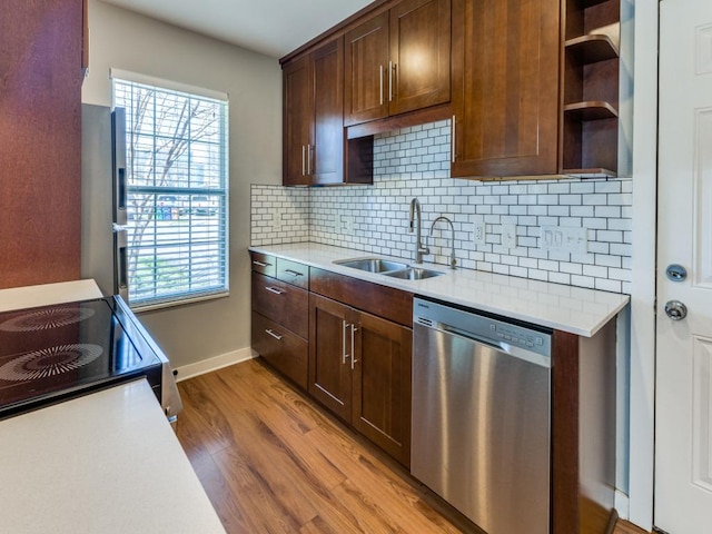 kitchen with open shelves, light wood-style flooring, a sink, light countertops, and appliances with stainless steel finishes