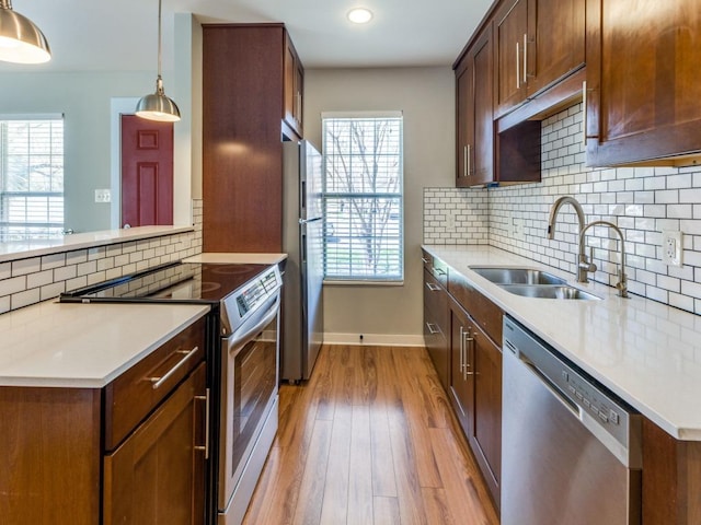 1105 Brookswood Ave, Austin, TX 78721 - kitchen with appliances with stainless steel finishes, healthy amount of natural light, light wood-style flooring, light countertops, and recessed lighting