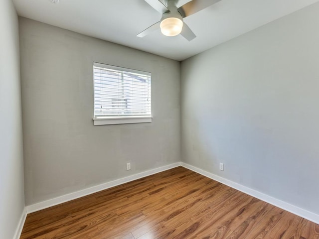 unfurnished room with a ceiling fan, wood finished floors, and baseboards