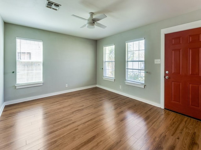 entrance foyer featuring a ceiling fan, wood finished floors, visible vents, and baseboards