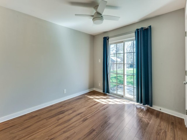 empty room featuring a ceiling fan, wood finished floors, and baseboards