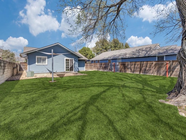 view of yard with central AC and a fenced backyard