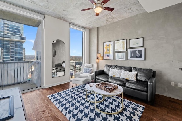 living area featuring a wall of windows, a city view, wood finished floors, and ceiling fan