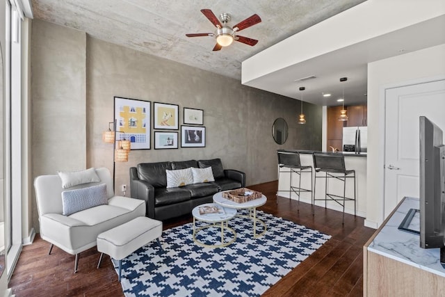 living area featuring dark wood-type flooring and ceiling fan