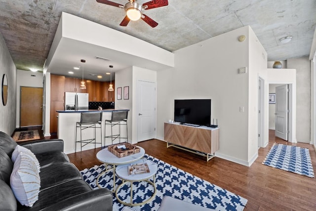 living area with dark wood-style floors, visible vents, ceiling fan, and baseboards