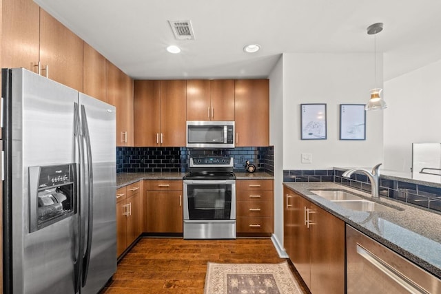 kitchen featuring a sink, brown cabinetry, visible vents, and stainless steel appliances