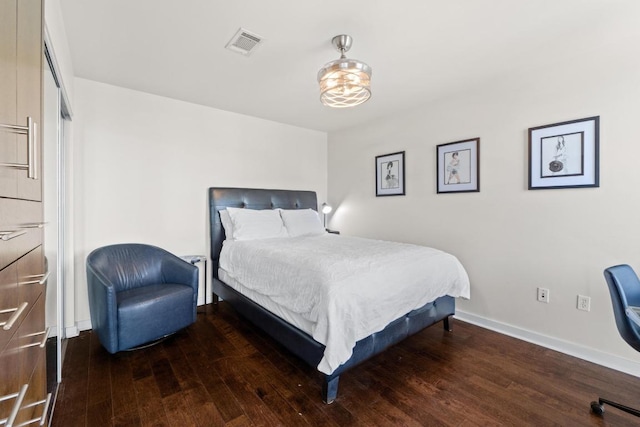 bedroom with visible vents, baseboards, and wood finished floors