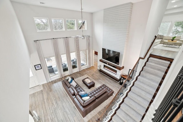 living room featuring stairway, a towering ceiling, and wood finished floors