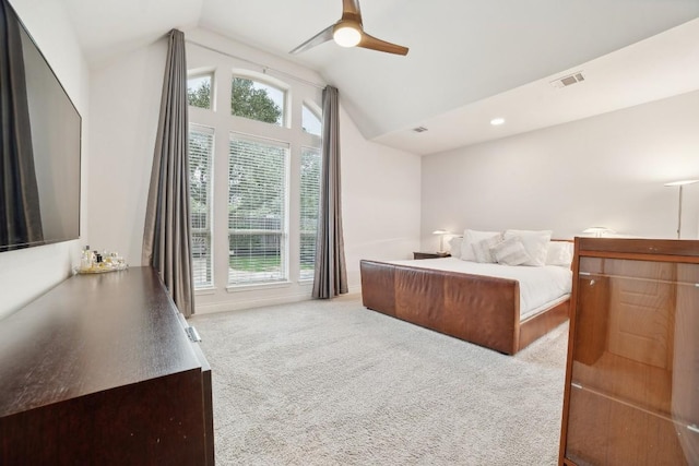 carpeted bedroom featuring visible vents, multiple windows, a ceiling fan, and vaulted ceiling