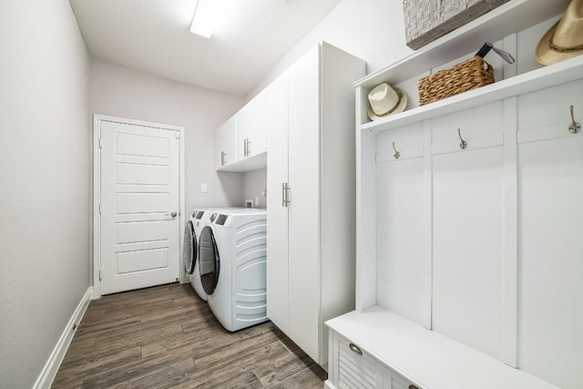 laundry room with washer and clothes dryer, cabinet space, dark wood finished floors, and baseboards