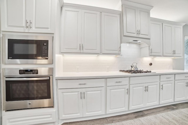 kitchen featuring stainless steel appliances, tasteful backsplash, and light countertops