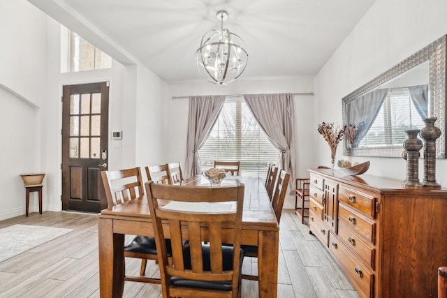 dining room with a chandelier, baseboards, and wood tiled floor