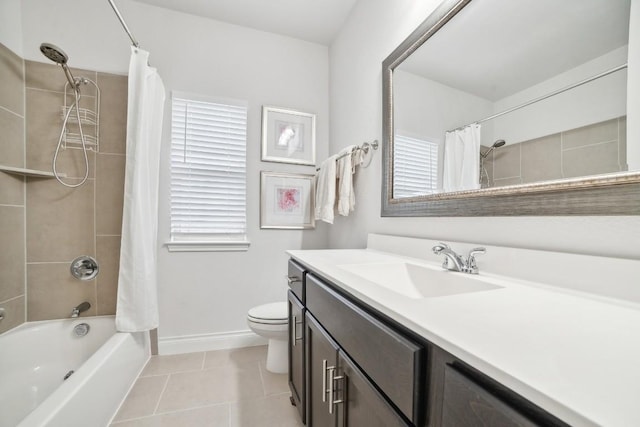 full bathroom featuring tile patterned floors, toilet, shower / bath combination with curtain, baseboards, and vanity