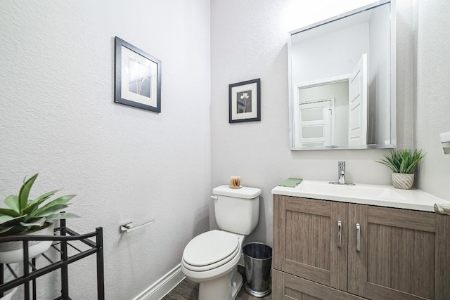 bathroom featuring vanity, toilet, and baseboards