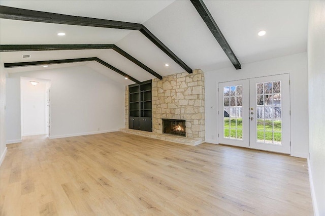 unfurnished living room featuring wood finished floors, baseboards, vaulted ceiling with beams, a stone fireplace, and french doors