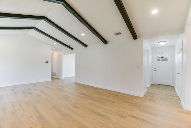 unfurnished living room featuring visible vents, baseboards, light wood-style floors, and vaulted ceiling with beams