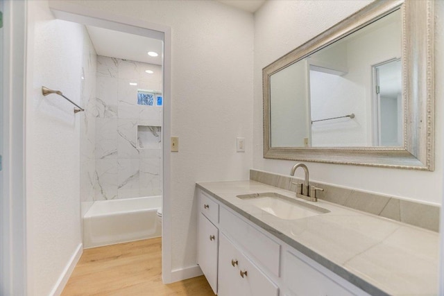 full bathroom featuring vanity, wood finished floors, baseboards, and shower / bath combination