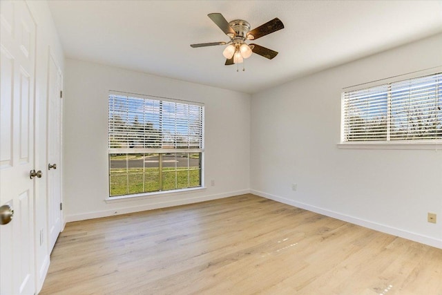 unfurnished room featuring a ceiling fan, wood finished floors, and baseboards